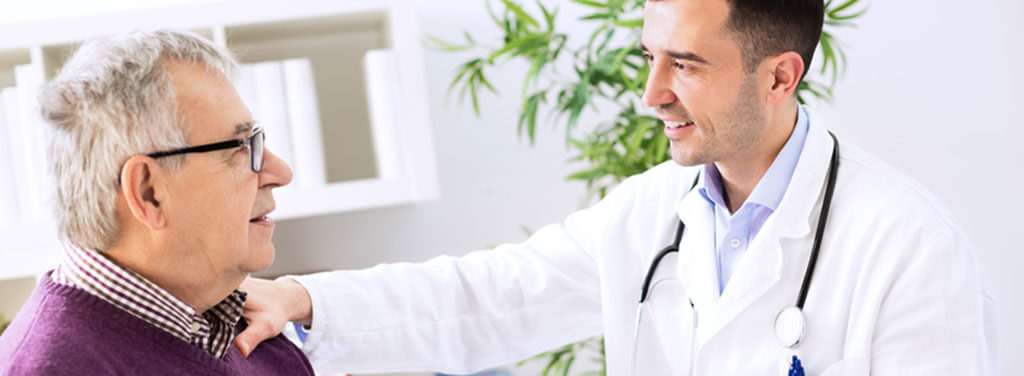 Elderly man with glasses consulting a male doctor