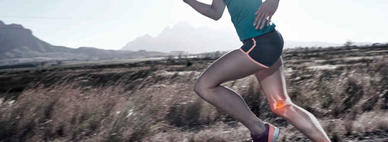 Woman running in mountainous landscape, digital overlay of knee bones
