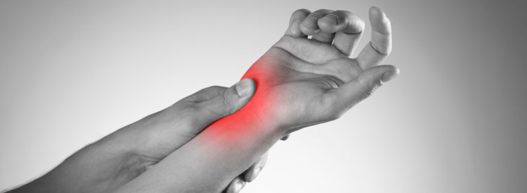 Black and white image of woman holding her right wrist, red glow signifying wrist pain