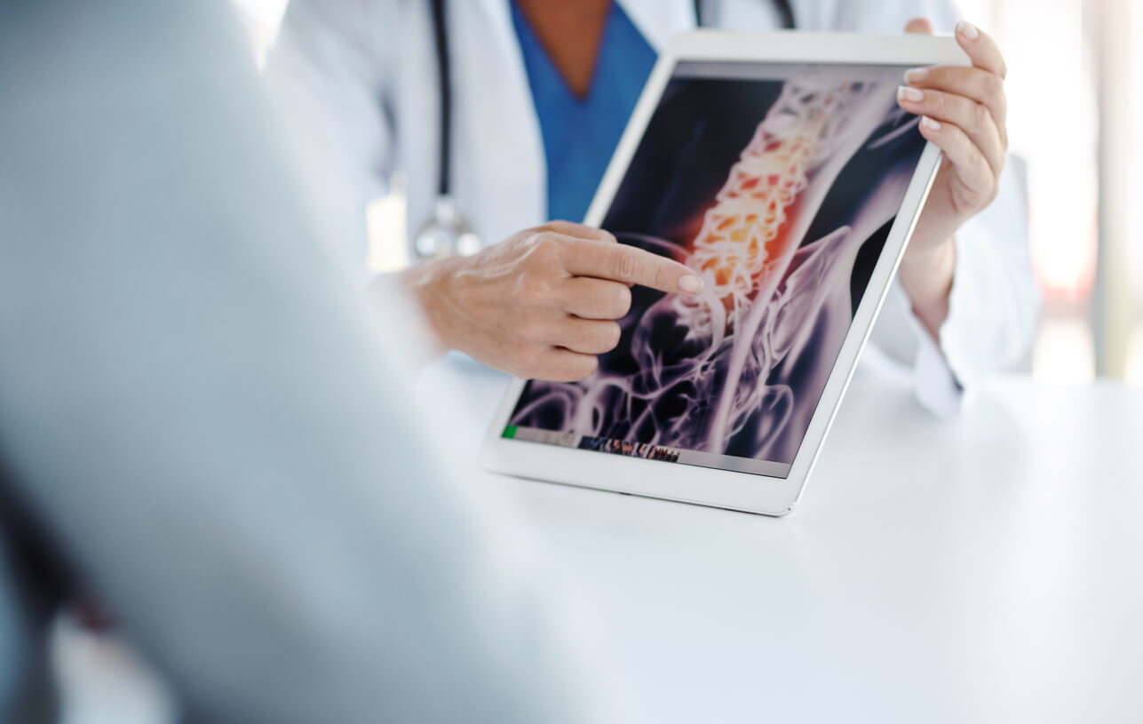 Doctor showing a patient an x-ray of their spine.