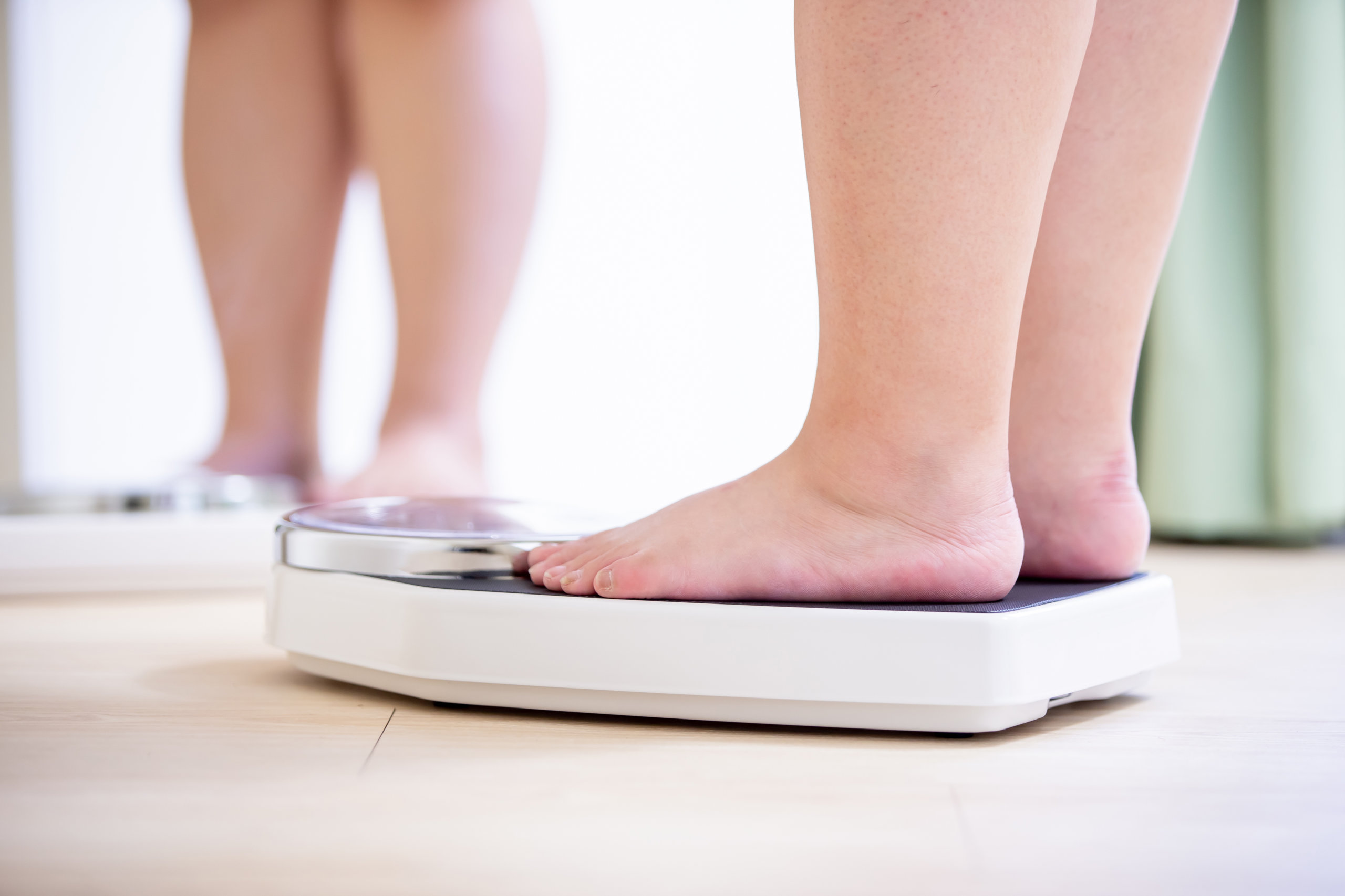 Obese child standing on a scale.