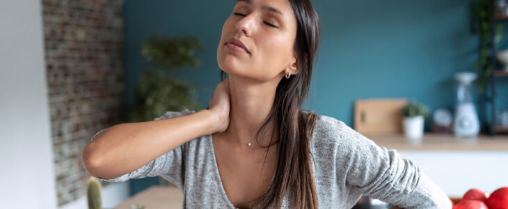 Woman holding neck in pain