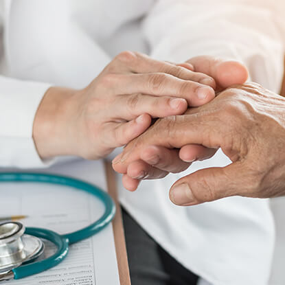 Doctor holding the hand of an elderly patient