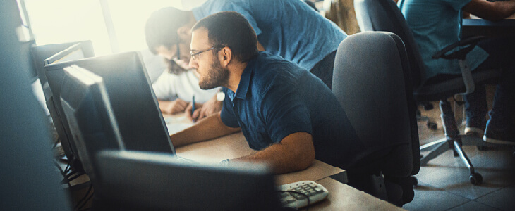 A man slouched over his computer chair