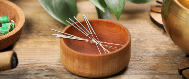 Acupuncture needles in a wooden dish