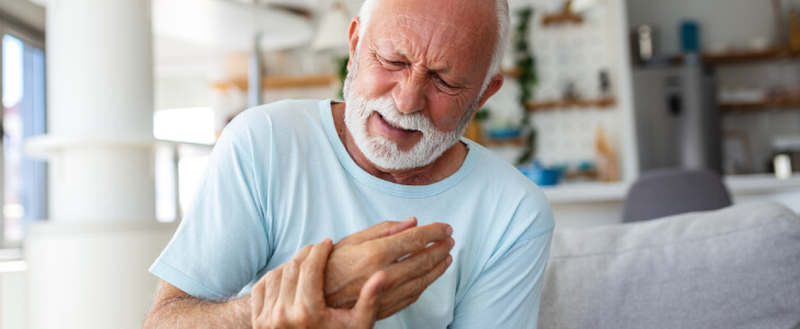 Man holding hand in pain due to rheumatoid arthritis