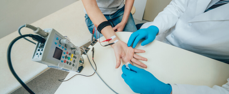 Doctor performing an EMG study on female patient