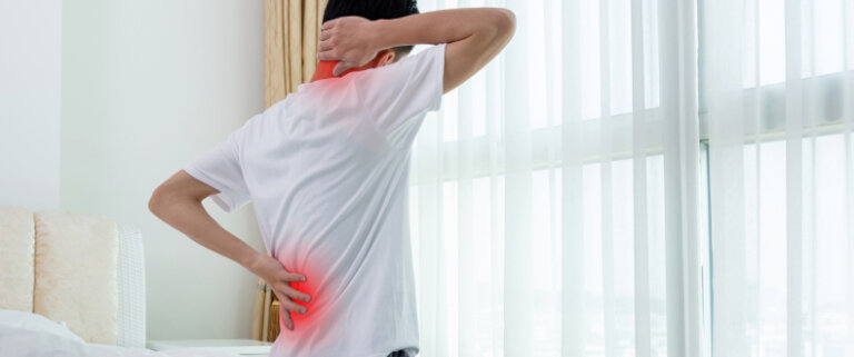 Man holding back and neck in pain
