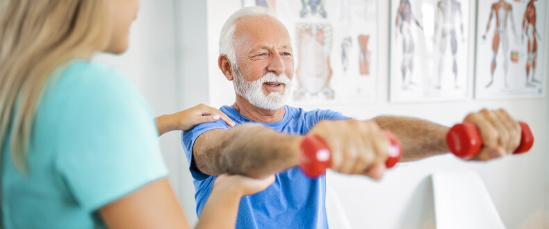 Elderly man lifting weights for physical therapy
