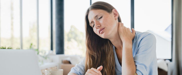 Woman holding neck with fibromyalgia pain