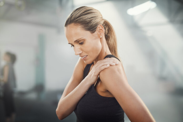 Woman holding shoulder experiencing joint pain.