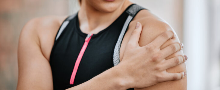 Unknown trainer alone in gym and suffering from shoulder injury.