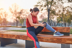 Young sportswoman having pain