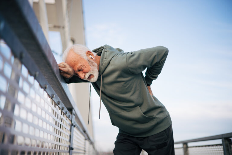 Sporty senior man having a back pain