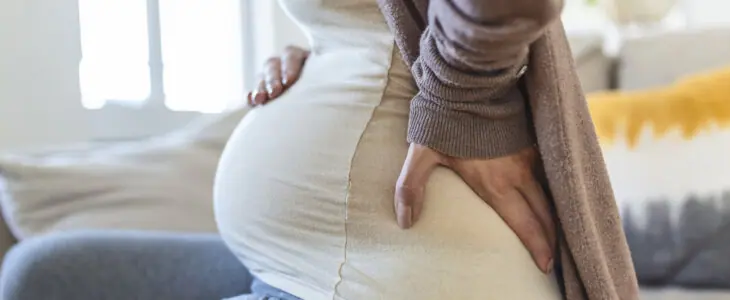 Pregnant woman holding back in pain