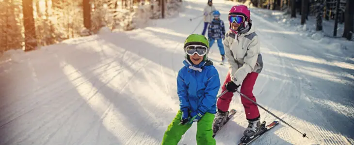 Mother with kids are skiing together down the ski slope