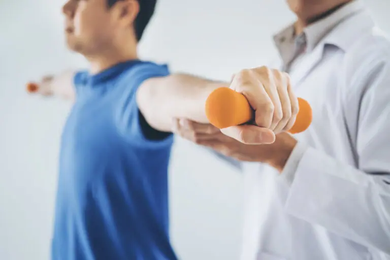Physiotherapist man giving exercise with dumbbell treatment